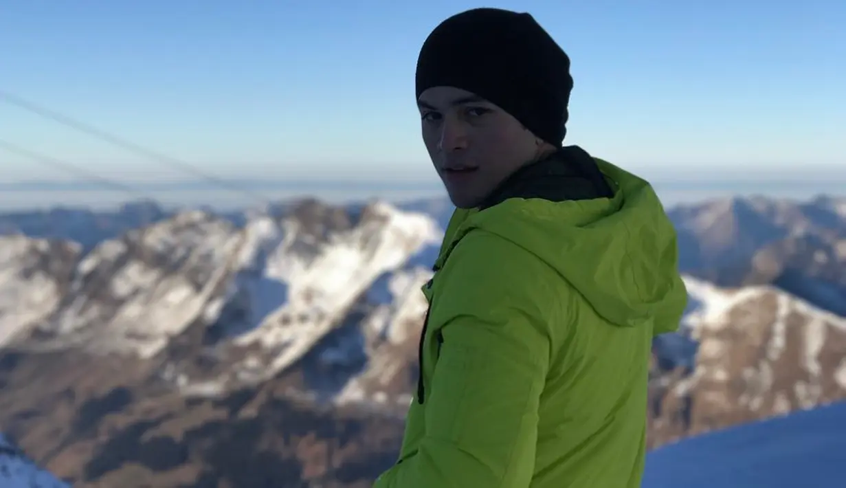 Enggak melulu topi baseball, pemeran film 'Magic Hour' ini terkadang menggunakan bonnie atau kupluk. Topi bonnie memang cocok untuk menikmati pemandangan hamparan salju di Switzerland. (Liputan6.com/IG/@rizkynazar20)