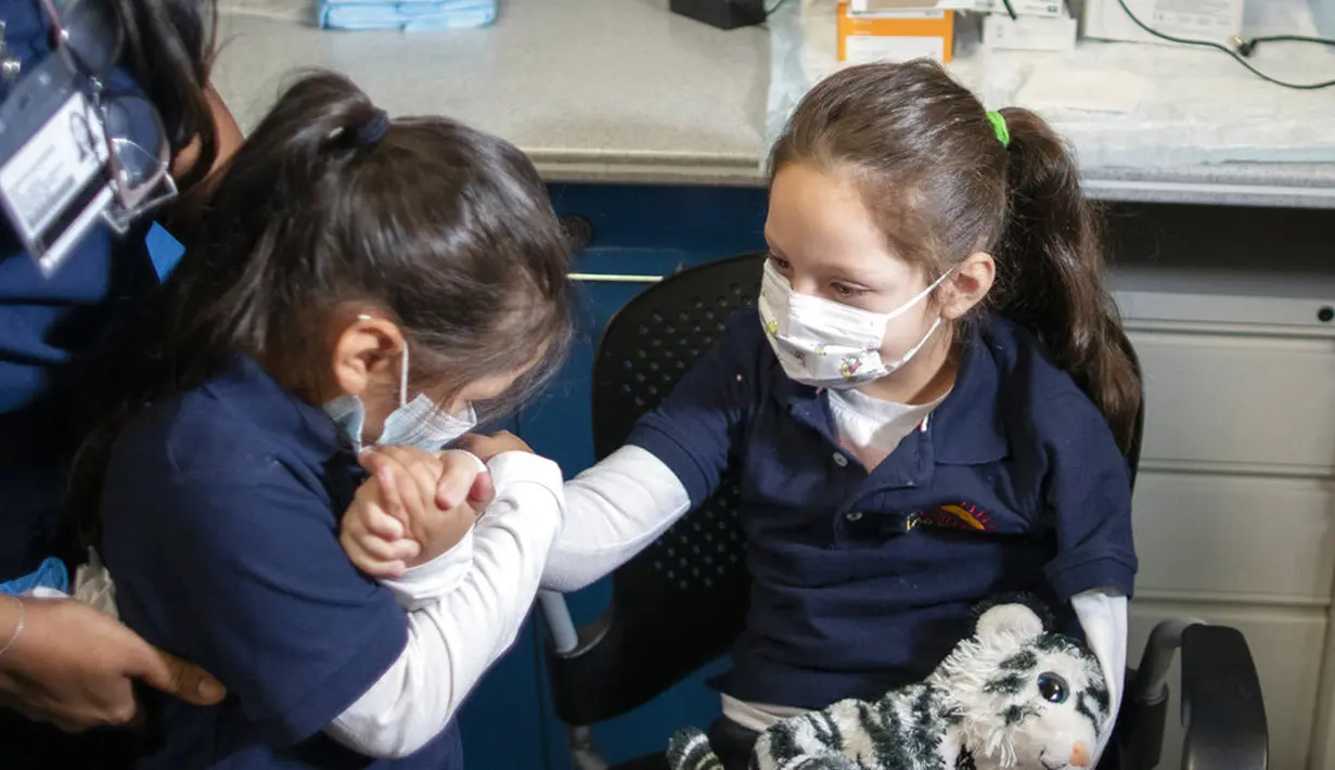 Harley Aviles, 5, (kanan) dihibur oleh saudara perempuannya sebelum menerima vaksinasi COVID-19 di Rumah Sakit Elmhurst, Queens, New York, Amerika Serikat, 5 November 2021. AS gelar vaksinasi COVID-19 untuk anak-anak berusia 5-11 tahun. (AP Photo/Eduardo Munoz Alvarez)