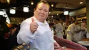 Pengusaha restoran sushi Jepang, Kiyoshi Kimura mencicipi tuna sirip biru seberat 278 kg di restorannya, Tokyo, Sabtu (5/1). Tuna raksasa itu dibeli dalam lelang perdana 2019 dengan harga USD3,1 juta atau setara Rp43,4 miliar. (Kazuhiro NOGI/AFP)