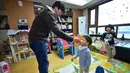 Kim Jin-Sung memberikan obat dingin untuk anaknya Won-Woo di apartemen mereka di Seoul. Sebuah ide yang tak biasa dimana anak sehari-hari dapat diurus oleh seorang pria yang merupakan tanggung jawab wanita. (AFP PHOTO/JU)