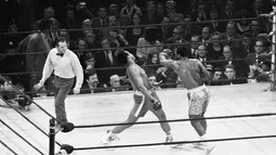 Muhammad Ali menghindar dari pukulan hook kiri dari lawannya Joe Frazier selama ronde pertama dalam turnamen tinju kelas berat di Madison Square Garden di New York, AS, 8 Maret 1971. (REUTERS/Action Images/MSI)