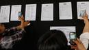 Awak media mengambil gambar daftar nama korban yang sudah berhasil diidentifkasi akibat jatuhnya pesawat Hercules C-130 milik TNI AU di Medan pada 30 Juni 2015, di Pangkalan Udara Halim Perdanakusuma, Jakarta, Rabu (1/7/2015). (Liputan6.com/Faizal Fanani)