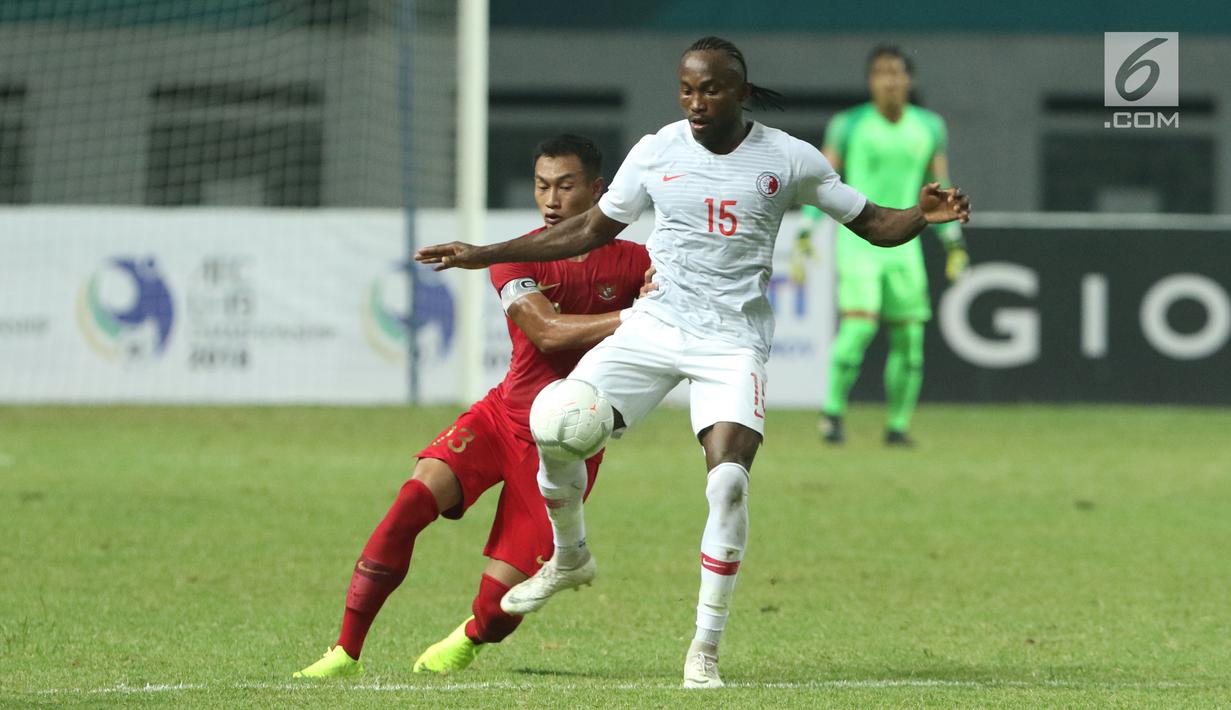 Pemain Timnas Indonesia, Hansamu Yama Pranata (kiri) berebut bola dengan pemain Hong Kong pada laga uji coba internasional di Stadion Wibawa Mukti, Cikarang, Selasa (16/10). Babak pertama, Indonesia unggul 1-0. (Liputan6.com/Helmi Fithriansyah)