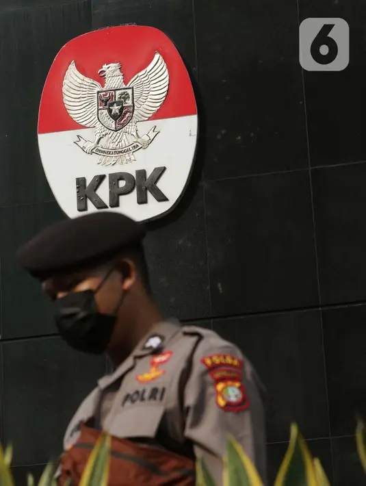 Petugas dari kepolisian melintas di dekat logo KPK di lobby Gedung Merah Putih KPK, Jakarta, Selasa (1/6/2021). Pengamanan gedung KPK dan sekitarnya diperketat terkait upacara pelantikan pegawai KPK menjadi Aparatur Sipil Negara. (Liputan6.com/Helmi Fithriansyah)