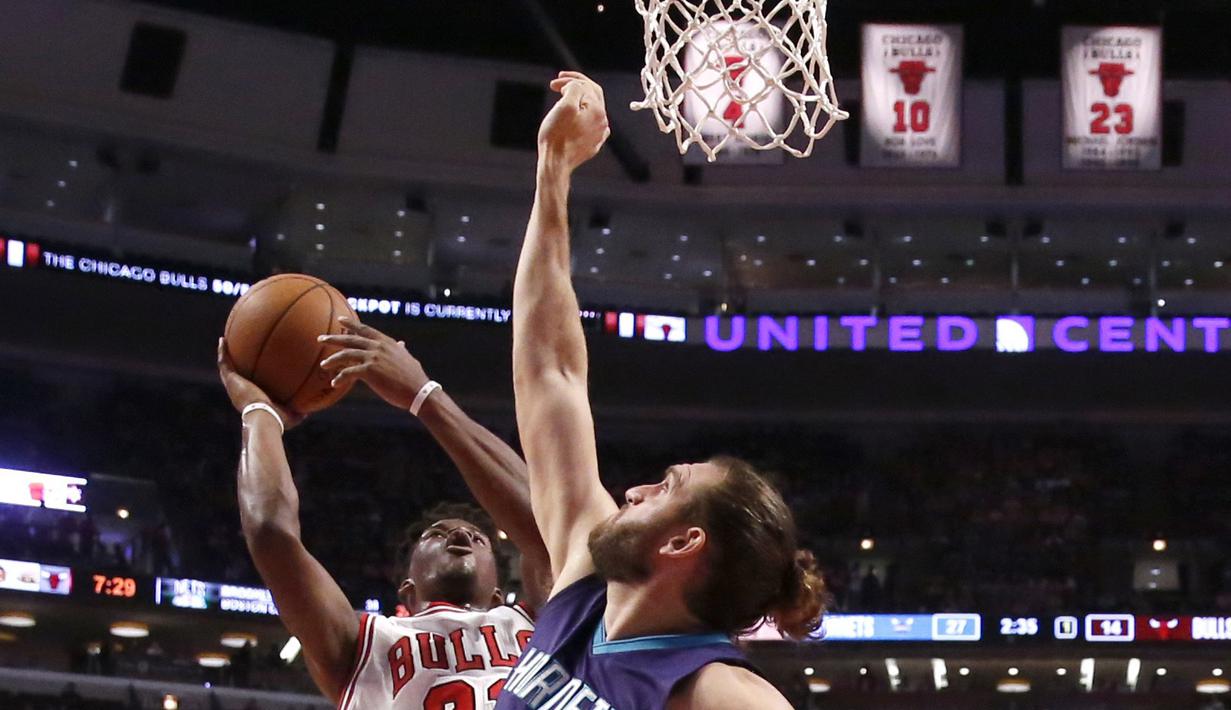 Pemain Chicago Bulls, Jimmy Butler (kiri) mencoba melakukan tembakan saat dihadang pemain Charlotte Hornets, Spencer Hawes pada laga NBA preseason basketball game di Chicago, Selasa (18/10/2016) WIB.  (AP/Charles Rex Arbogast)