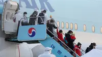 Warga Korea Selatan yang dievakuasi dari dari Wuhan, China, menuruni pesawat charter di Bandara Internasional Gimpo di Seoul pada Jumat (31/1/2020). Pesawat sewaan tersebut membawa pulang 367 warga negara Korea Selatan dari Wuhan, pusat wabah virus corona. (Kim Kyun-hyun/Newsis via AP)