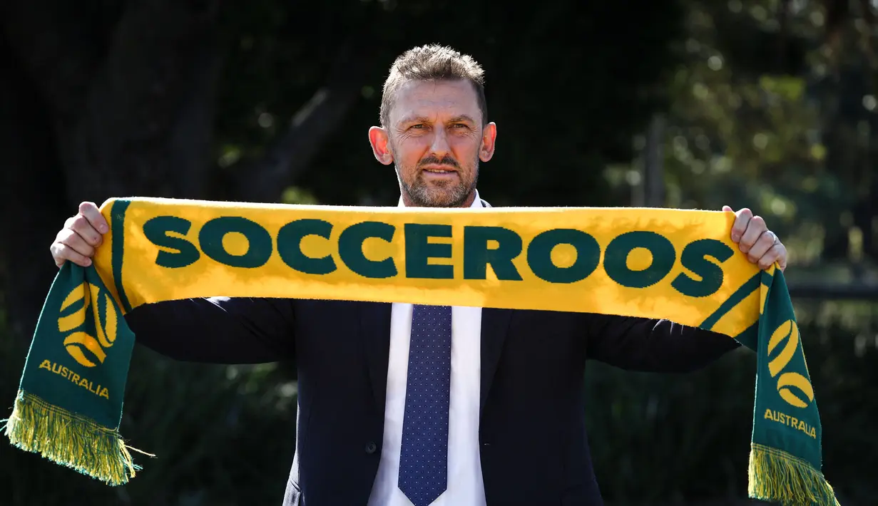 Tony Popovic, pelatih kepala yang baru ditunjuk untuk tim sepak bola nasional Australia, berpose dengan syal setelah konferensi pers di Sydney pada 23 September 2024. (DAVID GRAY/AFP)