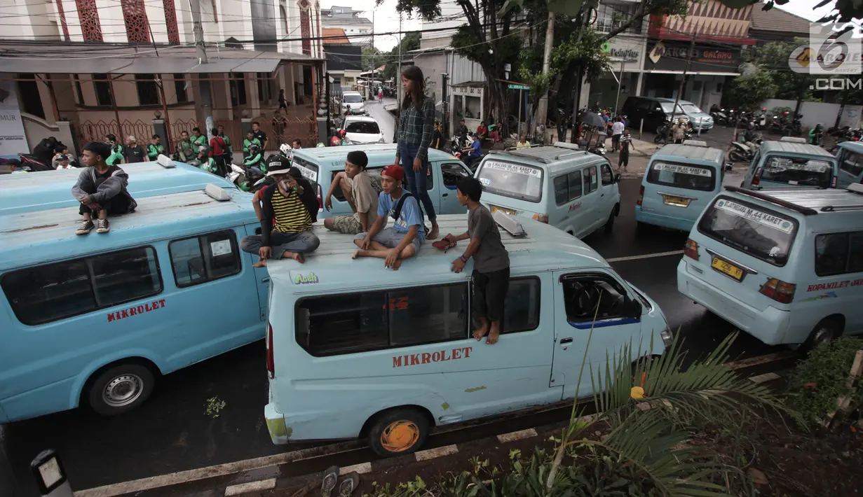 Sopir angkot trayek 44 (Jatinegara-Kampung Melayu-Tebet) melakukan unjuk rasa di sekitar Stasiun Tebet, Jakarta, Senin (12/2).  Mereka menuntut Pemprov DKI Jakarta untuk menyetop rute Transjakarta Kampung Melayu-Tanah Abang. (Liputan6.com/Arya Manggala)