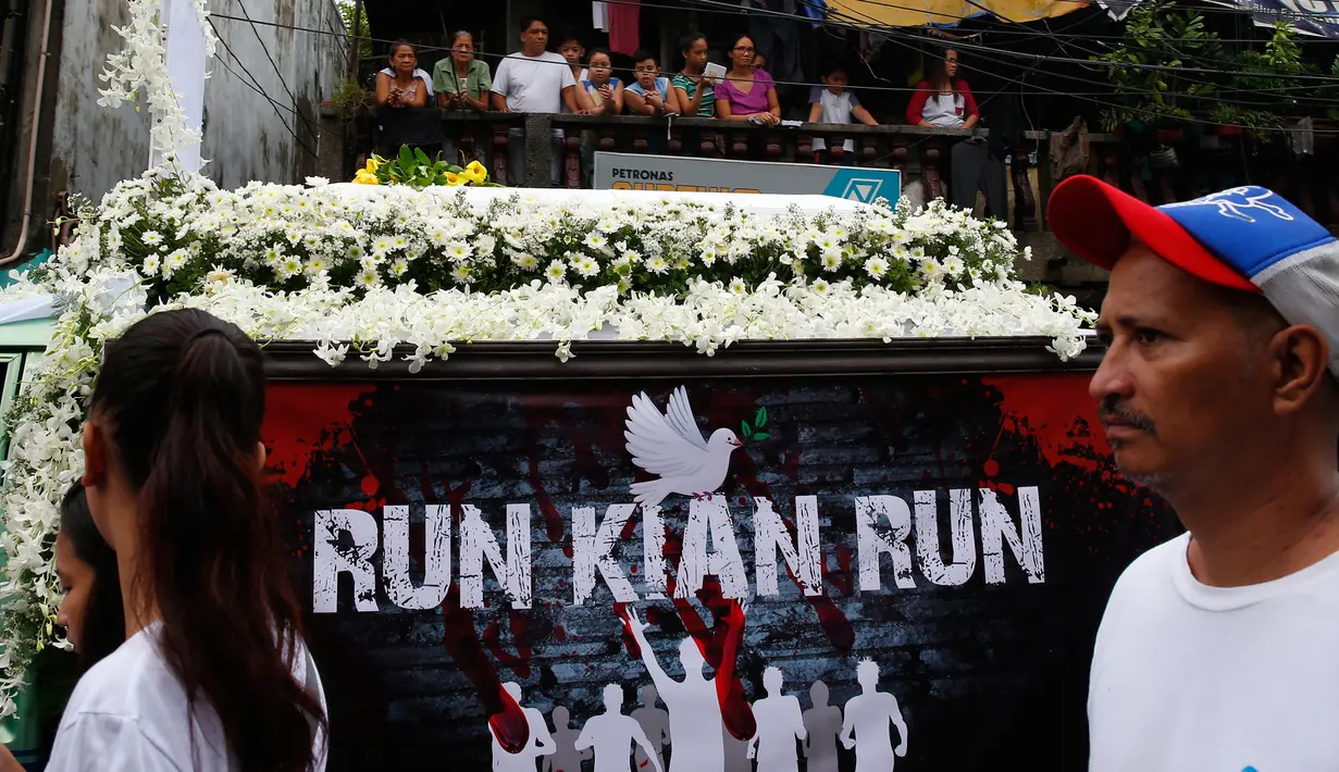 Sebuah mobil yang membawa jenazah Kian Loyd delos Santos diiringi para demonstran di Caloocan, Filipina (26/8). Dalam pemakaman itu lebih dari lima ribu orang berduka saat mengiringi pemakaman Kian Loyd. (AP Photo/Bullit Marquez)