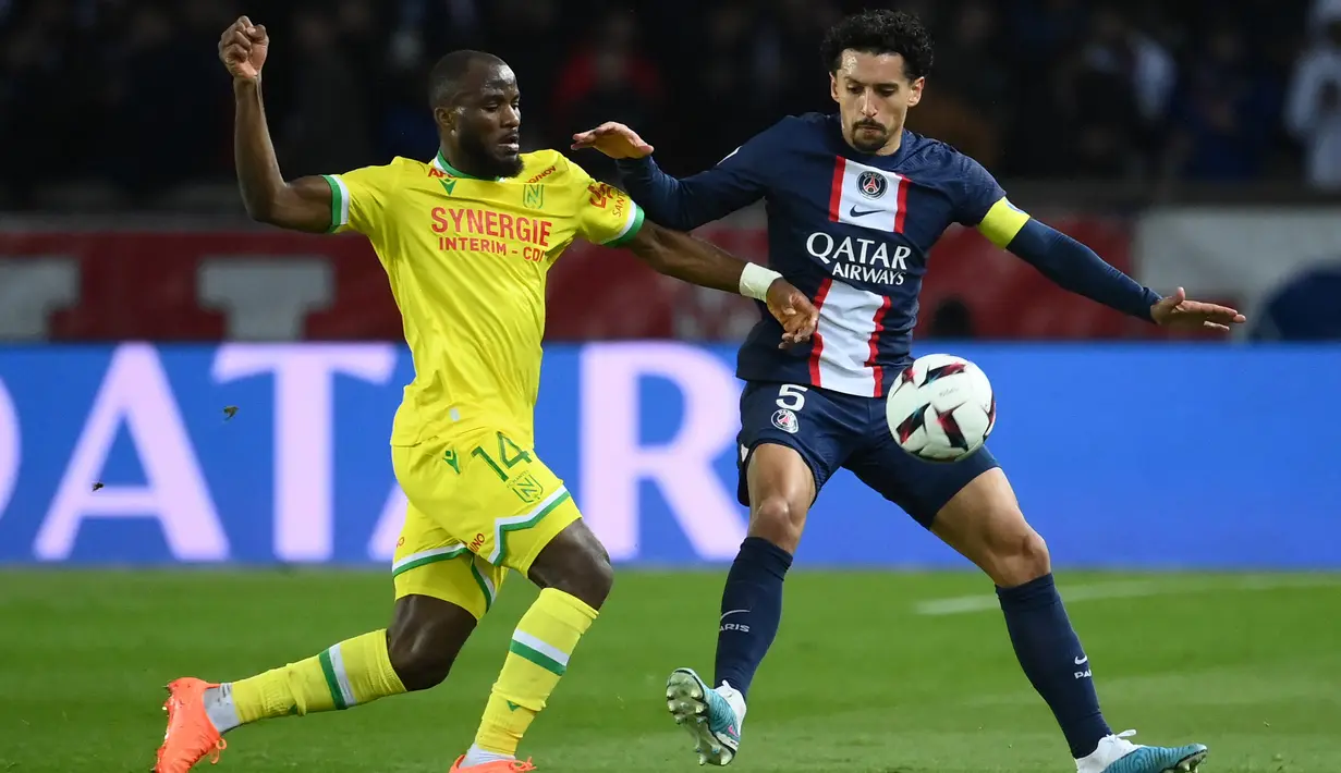 Penyerang Nantes, Igniatus Ganago (Kiri) bersaing dengan bek Paris Saint-Germain atau PSG, Marquinhos pada pekan ke-26 Ligue 1 atau Liga Prancis 2022-2023 di Parc des Princes, Minggu (5/3/2023) dini hari WIB. Bagi PSG hasil ini juga menjadi persiapan baik untuk menyongsong laga besar. (FRANCK FIFE / AFP)