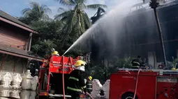 Petugas menyemprotkan air saat kebakaran di Hotel Istana Kandawgyi di Yangon, Myanmar (19/10). Api telah melahap hotel bintang lima yang sering dikunjungi wisatawan asing di kota Yangon, Myanmar. (AP Photo/Thein Zaw)