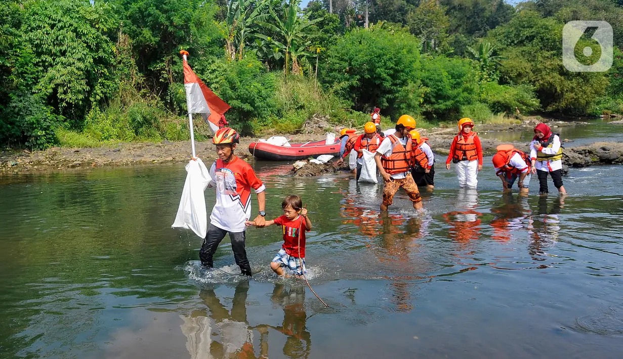 Usai upacara, peserta membersihkan sampah di Kali Ciliwung sambil membawa bendera Merah Putih. (merdeka.com/Arie Basuki)