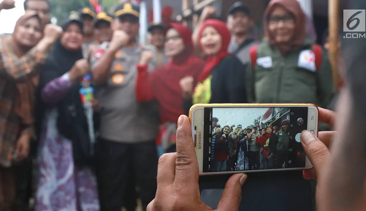 Kapolda Metro Jaya Irjen Gatot Eddy Pramono foto bersama warga saat meninjau persiapan TPS di Kampoeng Pemilu Nusantara, Depok, Jawa Barat, Selasa (16/4). Peninjauan tersebut untuk memastikan persiapan dan keamanan penyelenggaraan pemilu serentak 17 April 2019. (Liputan6.com/Immanuel Antonius)
