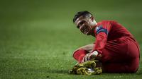 Gelandang Portugal, Cristiano Ronaldo, kesakitan saat melawan Ukraina pada laga Kualifikasi Piala Eropa 2020 di Stadion Luz, Lisbon, Jumat (22/3). Kedua negara bermain imbang 0-0. (AFP/Patricia De Melo Moreira)
