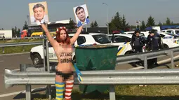 Aktivis perempuan Femen bertanjang dada membawa poster Presiden Ukraina Petro Poroshenko dan mantan Presiden Georgia Mikhail Saakashvili di perbatasan Ukraina-Polandia, di Ukraina, (10/9). (AFP Photo/Yuri Dyachyshyn)