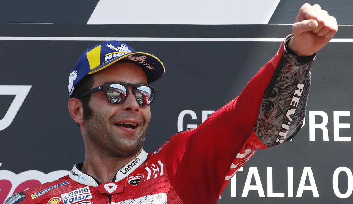 Pebalap Ducati, Danilo Petrucci, melakukan selebrasi usai menjuarai MotoGP Italia 2019 di Sirkuit Mugello, Minggu (2/6). Petrucci berhasil menuntaskan balapan 23 lap dengan catatan waktu 41 menit 33,794 detik. (AP/Antonio Calanni)