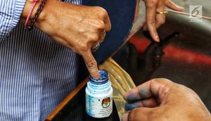Warga memasukkan jarinya ke dalam botol berisi tinta saat simulasi pemungutan dan pencoblosan surat suara Pemilu 2019 di Taman Suropati, Jakarta, Rabu (10/4). Simulasi dilakukan untuk meminimalisir kesalahan dan kekurangan saat pencoblosan pemilu pada 17 April nanti. (Liputan6.com/Johan Tallo)