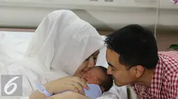 Gubernur Jambi Zumi Zola dan istri, Sherrin Tharia, mencium anak ke 2 mereka usai jumpa pres di Rumah Sakit kawasan Pondok Indah, Jakarta, Kamis (23/6). Anak ke 2 Zumi Zola lahir pada rabu (22/6) pukul 12.53. (Liputan6.com/Herman Zakharia)