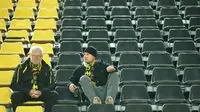 Dua suporter Borussia Dortmund masih bertahan di Stadion Signal Iduna Park, Selasa (11/4/2017), meski tahu laga melawan AS Monaco ditunda selama sehari. (AFP/Odd Andersen)