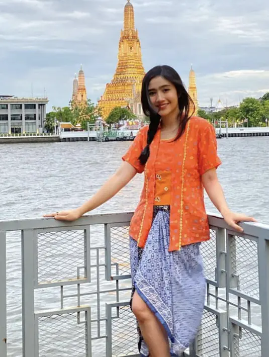 Febby Rastanty mengenakan kebaya oranye saat liburan di Bangkok dipadukan kain batik biru. Instagram/@febbyrastanty