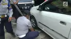 Petugas Dishub Jakarta Pusat menderek mobil yang parkir di trotoar jalan di kawasan jalan Gajah Mada
