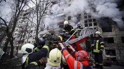 Petugas pemadam kebakaran mengevakuasi seorang pria dari gedung apartemen yang terkena tembakan di Kyiv, Ukraina (14/3/2022). Dua orang tewas pada 14 Maret 2022 akibat serangan penembakan dan rudal Rusia yang menghancurkan gedung apartemen tersebut. (Ukrainian State Emergency Service via AP)