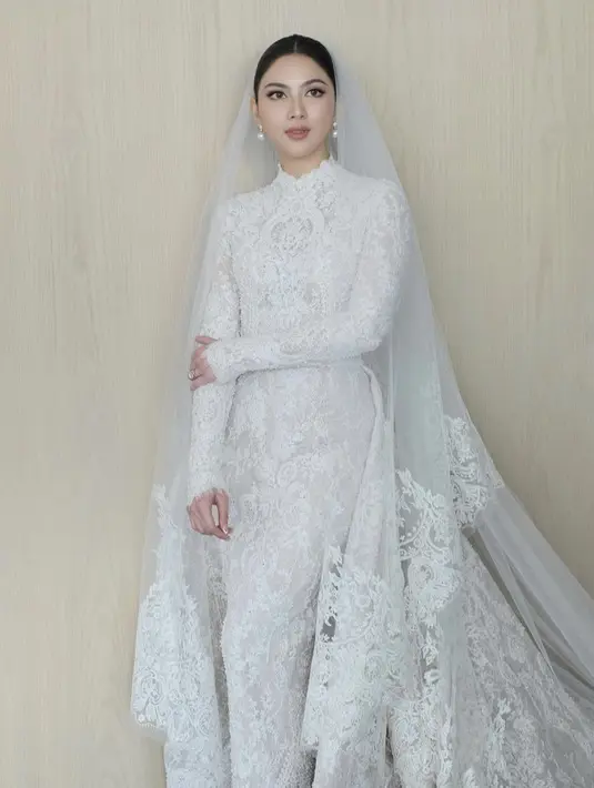 Jessica Mila tampil bak Princess di hari pernikahannya, ia tampil mengenakan gaun putih lace lengan panjang dengan detail tertule neck. Credit: (@cherryjks)