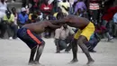 Dua pegulat sedang beraksi pada ajang gulat yang disebut Pinge wrestling competition di Port-au-Prince, Haiti, Sabtu (26/3/2016). Acara ini untuk memperingati Paskah di Haiti. (REUTERS/Andres Martinez Casares)