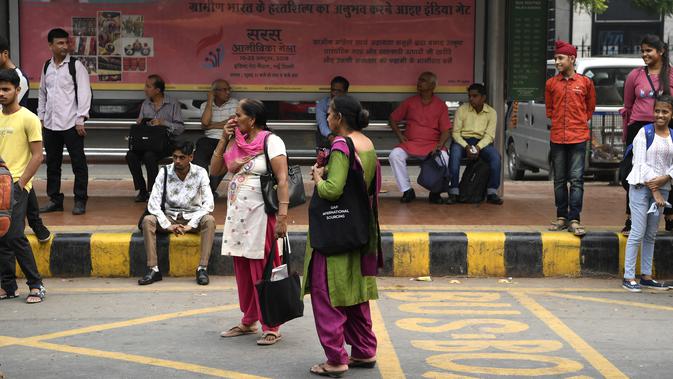 Seorang perempuan menunggu bus  New Delhi Transport Corporation untuk melakukan perjalanan gratis di New Delhi, 29 Oktober 2019. Pemerintahan teritorial ibu kota India, New Delhi, menerapkan kebijakan menggratiskan seluruh rute bus untuk kaum perempuan sejak 29 Oktober. (Sajjad HUSSAIN/AFP)