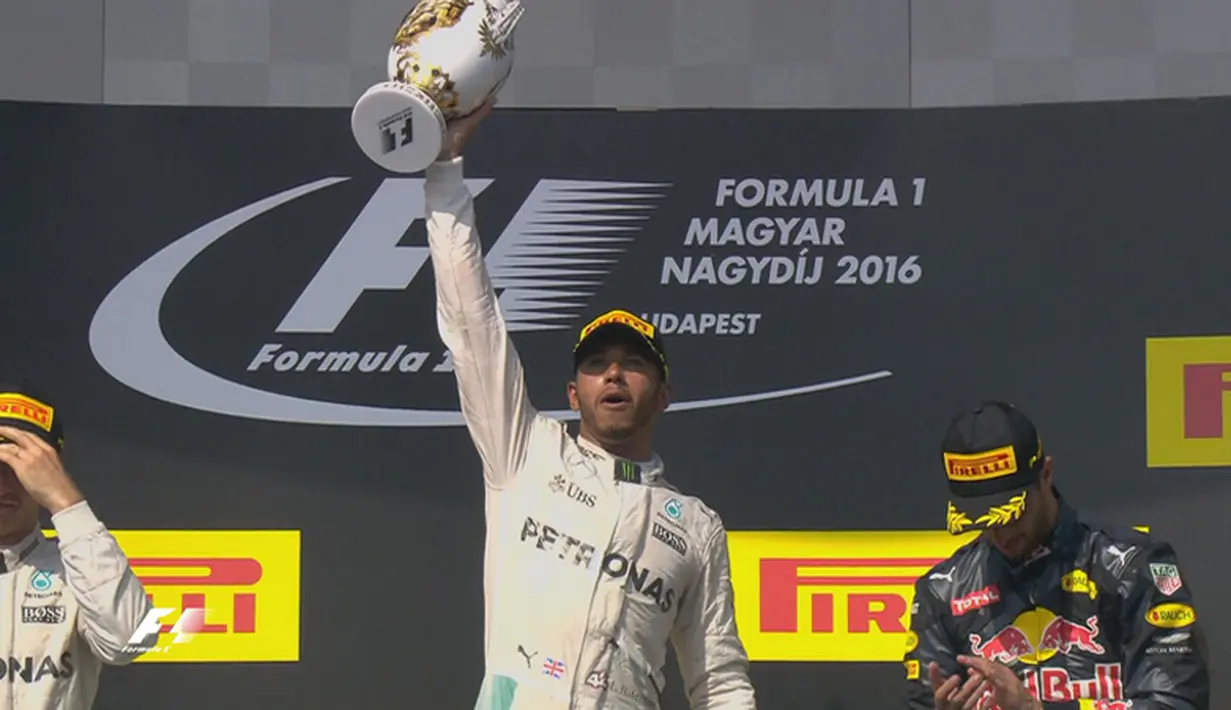 Ekspresi pebalap Mercedes, Lewis Hamilton, dengan trofi juara F1 GP Hungaria di Sirkuit Hungaroring, Budapest, Minggu (24/7/2016). Nico Rosberg berada di posisi kedua disusul Daniel Ricciardo. (Bola.com/Twitter/F1)