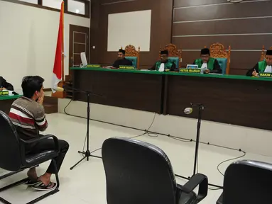 Salah seorang terdakwa pasangan sejenis (gay) di Aceh saat menghadiri persidangannya di pengadilan syariah di Banda Aceh (17/5). Majelis hakim Mahkamah Syar'iyah Banda Aceh memvonis terdakwa dengan 85 kali cambuk. (AFP/Chaideer Mahyuddin)