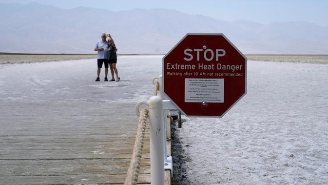 Tanda peringatan bahaya panas ekstrem di Badwater Basin, Taman Nasional Death Valley, California, AS, Senin (17/8/2020). Suhu terpanas di dunia terpantau terjadi di Taman Nasional Death Valley yang mencapai 130 derajat Fahrenheit (54,4 derajat Celcius) pada Minggu 16 Agustus. (AP Photo/John Locher)