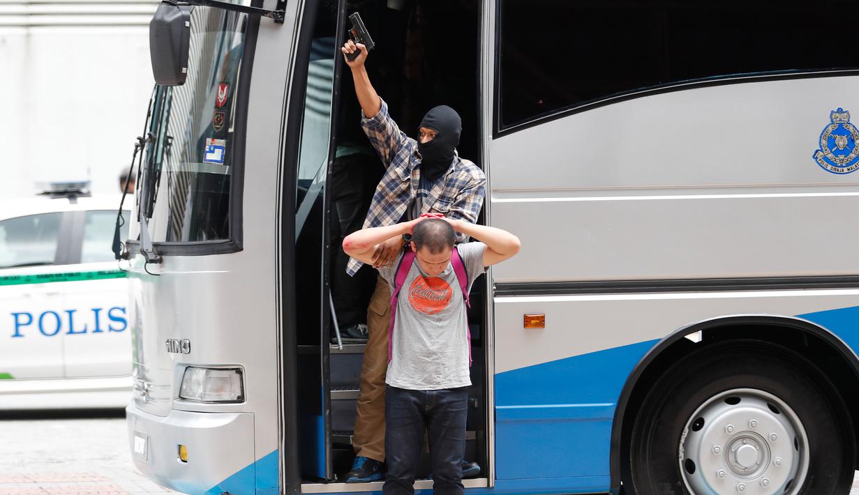 Anggota Petugas Polisi Malaysia Raya yang bertindak sebagai teroris menyandra seorang penonton saat latihan persiapan SEA Games Asia Tenggara di Kuala Lumpur, Malaysia, (20/7). (AP Photo/Vincent Thian)