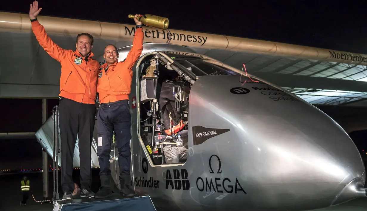Pilot Swiss Bertrand Piccard (kanan) foto bersama dengan Andre Borschberg setelah mendaratkan pesawat bertenaga surya di Moffett Airfield di Mountain View, California, AS (23/4). (Jean Revillard/Solar Impulse/Reuters)