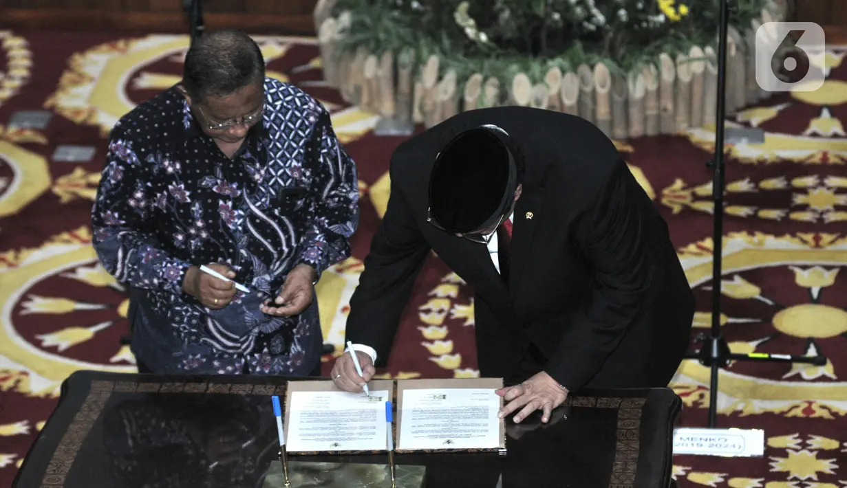 Airlangga Hartarto (kanan) bersama Darmin Nasution menandatangani berita acara serah terima jabatan Menteri Koordinator Bidang Perekonomian di Kemenko Perekonomian, Jakarta, Rabu (23/10/2019). Airlangga secara resmi menggantikan Darmin Nasution sebagai Menko Perekonomian. (merdeka.com/Iqbal Nugroho)