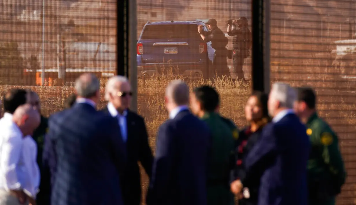 Dengan pihak berwenang di Ciudad Juarez, Meksiko, sebagai latar belakang, Presiden Amerika Serikat Joe Biden berbicara dengan agen dan pejabat Patroli Perbatasan AS di sepanjang perbatasan AS-Meksiko di El Paso, Texas, AS, 8 Januari 2023. Biden mengatakan bahwa para imigran akan dideportasi ke Meksiko jika memasuki AS secara ilegal. (AP Photo/Andrew Harnik )