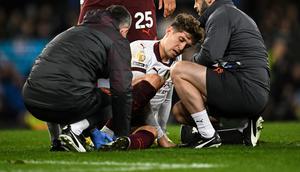 Bek Manchester City, John Stones, mendapatkan perawatan saat bertanding melawan Everton di Goodison Park dalam laga pekan 19 Liga Inggris 2023/2024, Kamis (28/12/2023) dini hari WIB. John Stones harus keluar lapangan karena mengalami cedera pergelangan kaki. (Paul ELLIS / AFP)