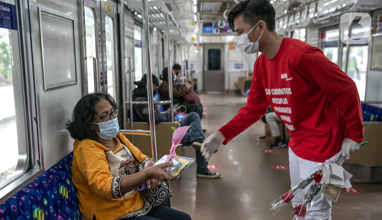 Petugas KAI Commuter (kanan) memberikan bunga dan healthy kit kepada perempuan pengguna KRL di Stasiun Jatinegara, Jakarta, Selasa (22/12/2020). Kegiatan tersebut dalam rangka memperingati Hari Ibu yang jatuh setiap tanggal 22 Desember. (Liputan6.com/Faizal Fanani)