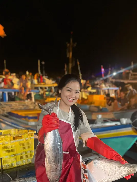 Unggahan istri Christian Sugiono itu menarik perhatian warganet. Dalam video  singkat yang diunggah, wanita dua orang anak itu mengenakan pakaian sederhana. Senyum Titi mengangkat ikan besar. [Instagram/titi_kamall]