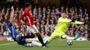 Kiper Chelsea, Thibaut Courtois berusaha menghalau tendangan gelandang MU, Jesse Lingard pada Liga Inggris di Stadion Stamford Bridge, London, Inggris (23/10). Chelsea menang atas MU dengan skor akhir 4-0. (Reuters/John Sibley)