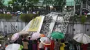 Warga menonton Jembatan Penyeberangan Orang (JPO) yang roboh akibat hujan deras dan angin kencang di Jalan Raya Pasar Minggu, Jakarta Selatan, Sabtu (24/09). Petugas masih memotong bagian JPO tersebut. (Liputan6.com/Immanuel Antonius)