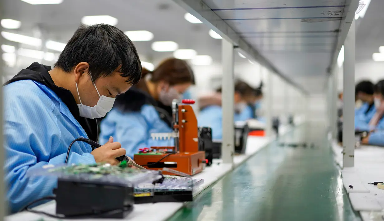 Aktivitas pekerja di sebuah pabrik elektronik di wilayah Xiushan, Chongqing, China barat daya, Jumat (27/2/2020). Kegiatan produksi dan kehidupan sehari-hari warga berangsur normal berkat upaya pengendalian virus corona COVID-19 yang efektif di Xiushan. (Xinhua/Liu Chan)