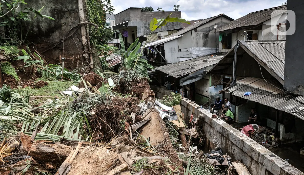 Warga saat membersihkan puing reruntuhan bangunan pascatanah longsor di kawasan Kemang Timur XI, Jakarta Selatan, Minggu (21/2/2021). Longsor merusak lima rumah warga serta menyumbat aliran kali. (merdeka.com/Iqbal S. Nugroho)