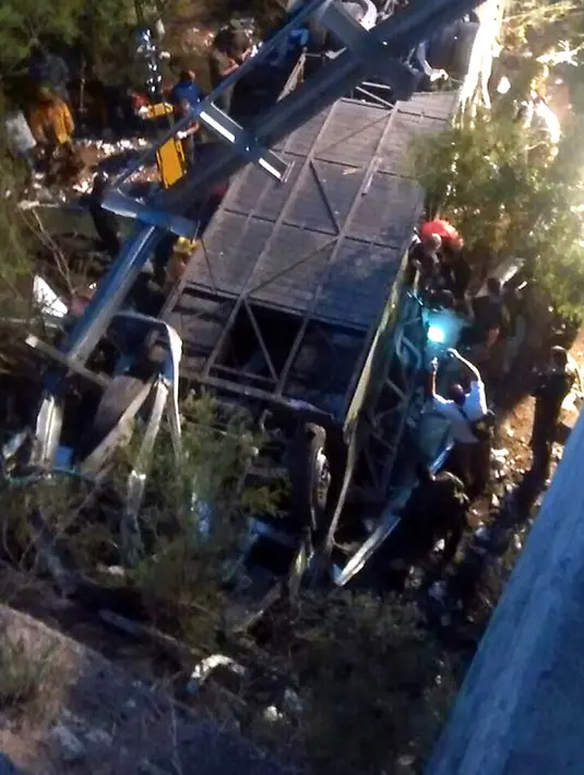 Petugas berusaha mengevakuasi bangkai bus yang jatuh dari sebuah jembatan di utara Provinsi Salta, Argentina, Senin (14/12). Sedikitnya 42 polisi tewas dan lainnya terluka ketika bus yang ditumpangi menabrak jembatan dan terjun ke jurang. (AFP Photo)