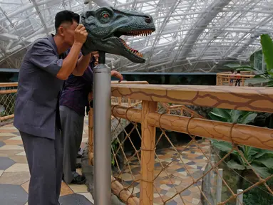 Seorang pria melihat melalui perangkat untuk mempelajari visi dinosaurus di Kebun Binatang di Pyongyang, Korea Utara (15/9). Kebun binatang nasional Korea Utara ini  terletak dekat Mt. Taesong di pusat kota Pyongyang. (AP Photo/Kin Cheung)