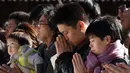 Warga memanjatkan doa Tahun Baru 2018 di Kuil Meiji, Tokyo, Jepang (1/1). Jutaan warga Jepang mengunjungi kuil-kuil di seluruh negeri selama tiga hari pertama tahun baru untuk berdoa demi kesejahteraan keluarga mereka. (AFP Photo/Kazuhiro Nogi)