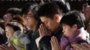 Warga memanjatkan doa Tahun Baru 2018 di Kuil Meiji, Tokyo, Jepang (1/1). Jutaan warga Jepang mengunjungi kuil-kuil di seluruh negeri selama tiga hari pertama tahun baru untuk berdoa demi kesejahteraan keluarga mereka. (AFP Photo/Kazuhiro Nogi)