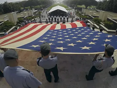 Anggota program Kahuku SMA Junior Cadangan Officer Training Corps (JROTC) membentangkan bendera nasional Amerika saat upacara peringatan Hari Veteran di Memorial Cemetery Nasional Pasifik di Honolulu, Hawaii, Rabu (11/11). (REUTERS/Hugh Gentry)