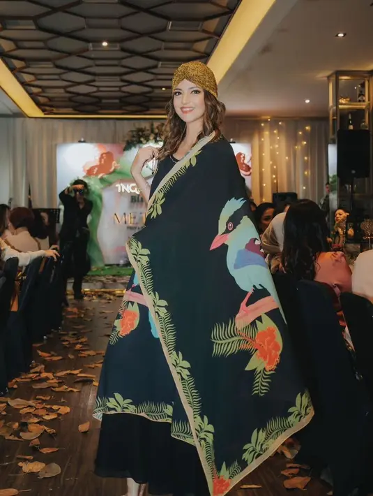 Penampilan memukau Nia Ramadhani dengan maxi dress warna hitam. Gayanya makin sempurna dengan turban instan yang dikenakan di kepalanya. [@ghearesort]