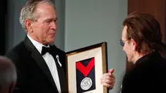 Presiden AS ke-43 George W. Bush (kiri) memberikan medali Distinguished Leadership kepada vokalis U2 Bono selama gala untuk Forum Kepemimpinan di Institut George W. Bush di Dallas, AS (19/4). (AP Photo/Brandon Wade)